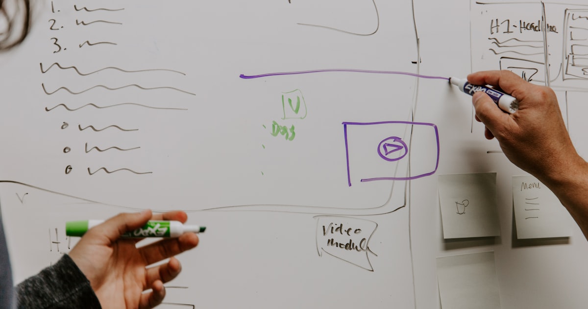 Two people mapping out ideas on a whiteboard during a naming and branding session